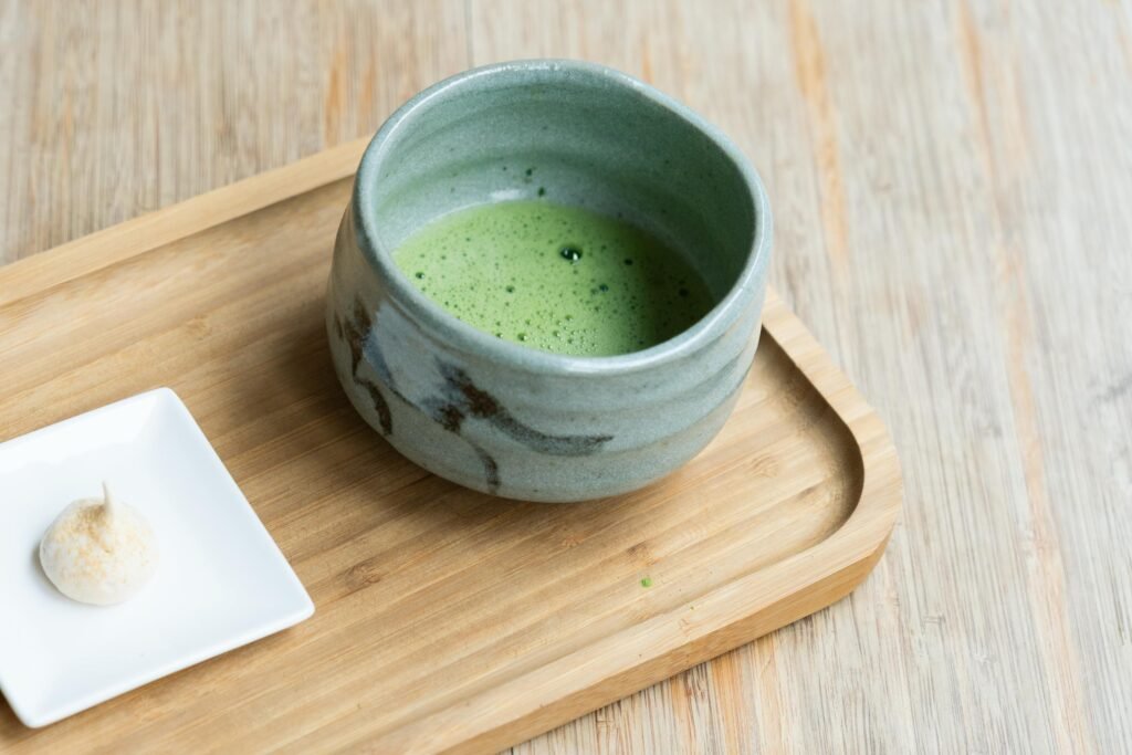 A serene matcha tea setup with a green tea bowl on a bamboo tray.